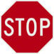 A red and white aluminum sign that says "Stop" in white letters.
