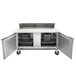 A Beverage-Air stainless steel refrigerated sandwich prep table with open doors on a counter in a professional kitchen.