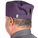 A man wearing a purple Uncommon Chef skull cap with a hook and loop closure.