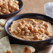 A bowl of hummus with chickpeas in it.
