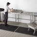 A man working on a large stainless steel Regency sorting table.