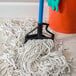 A blue Carlisle mop handle with a white mop on the floor.