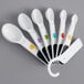 A group of OXO white measuring spoons.