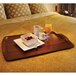 A Cambro walnut hotel room service tray with a bowl of fruit and a cup of coffee on it.