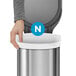 A person's hand holding a simplehuman white trash can liner with "N" on it.