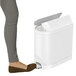 A woman stepping on a white simplehuman rectangular butterfly step-on trash can.