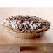 A close up of a chocolate pie with whipped cream on top in a D&W Fine Pack foil pie pan.