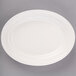 An ivory oval china platter with a decorative edge.