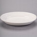 An ivory oval china platter with an embossed rim.