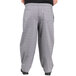 A person wearing Uncommon Chef Glen Plaid chef pants in grey.