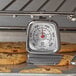 A Comark oven thermometer on a rack of cookies.