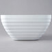 A pearl white Vollrath square serving bowl with a curved edge.