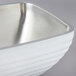 A pearl white Vollrath double wall metal serving bowl with a silver rim.