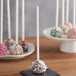EcoChoice white paper cake pops on a black plate with white sticks.
