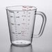 A clear Carlisle measuring cup with red and blue text showing measurements.