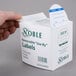 A hand holding a white box of Noble Products 3" Use By Round Removable Labels with a label on the front.