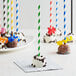 EcoChoice green striped paper cake pop sticks in chocolate cake pops with colorful straws.