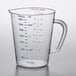 A Carlisle clear polycarbonate measuring cup with red and blue numbers and a handle.