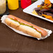 A Hoffmaster white paper fluted hot dog tray with a hot dog and chips with relish and sauce.