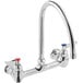 A silver Waterloo wall mount faucet with red knobs.
