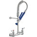 A silver Waterloo low profile wall-mounted pre-rinse faucet with blue handles.