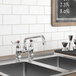 A Waterloo deck-mounted faucet on a counter above a kitchen sink with a blackboard on the wall.