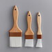 A Thunder Group 3-piece pastry and basting brush set with wooden handles.
