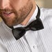 A man wearing a Henry Segal black poly-satin bow tie with an adjustable band.