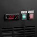 A black panel on an Avantco back bar cooler with a digital clock and temperature control with red numbers.