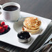 A Front of the House Harmony porcelain plate with pancakes and berries with a cup of coffee.