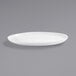 A white Front of the House Harmony coupe oval porcelain plate on a gray surface.