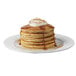 A stack of Krusteaz sweet potato pancakes with syrup and whipped cream.