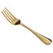 An Acopa Vernon stainless steel dinner fork with a gold handle.