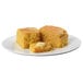A plate with two pieces of Southern-style cornbread and butter.