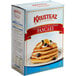 A box of Krusteaz Country Style Multigrain Pancakes with blueberries and bananas on top.
