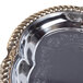 A silver metal oval catering tray with gold trim.
