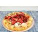 A plate of funnel cake topped with strawberries.
