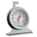 A close-up of a round metal Choice oven thermometer with a red and white dial.