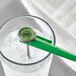 A green AvaTemp pocket probe thermometer gauge on a glass of water.