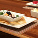 A Front of the House Kyoto rectangular porcelain plate with food on a table.