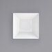 A white square bowl on a white surface.