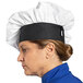 A woman wearing a white Uncommon Chef twill chef hat.