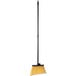 A Carlisle commercial broom with a black and yellow handle.