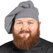 A bearded man wearing a Uncommon Chef Houndstooth twill chef hat.
