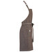 A brown Mercer Culinary apron with a belt and pockets.