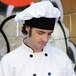 A man wearing a white Uncommon Chef custom chef hat.