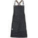 A black denim Mercer Culinary Renegade bib apron with brown leather straps.