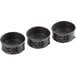 Three black round metal Wilton mini springform cake pans with handles.