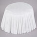 A white tablecloth with a pleated pattern on a table.