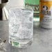 A glass of ice with a can of Polar tonic water on a table.